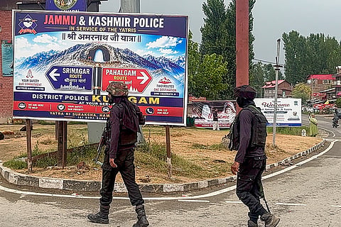 Security personnel stand guard along the Jammu-Srinagar National Highway following the suspension of the Amarnath Yatra from the Baltal and Pahalgam routes due to adverse weather conditions, in Anantnag district, Jammu and Kashmir, Sunday, July 19, 2026.