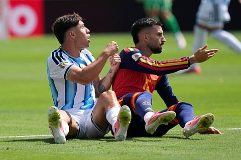 Argentina's Gonzalo Montiel (4) and Spain's Alex Baena (15) react after a fall during the World Cup final soccer match between Spain and Argentina in East Rutherford, N.J., near New York, Sunday, July 19, 2026.