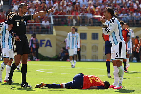 Referee Slavko Vincic, left, gestures as Argentina's Leandro Paredes (5) reacts and Spain's Pedro Porro (12) lies on the ground during the World Cup final soccer match between Spain and Argentina in East Rutherford, N.J., near New York, Sunday, July 19, 2026.