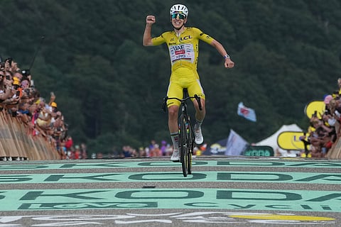 Slovenia's Tadej Pogacar, wearing the overall leader's yellow jersey, celebrates as he crosses the finish line to win the fourteenth stage of the Tour de France cycling race with start in Mulhouse and finish in Le Markstein Fellering, France.
