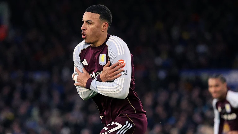 Morgan Rogers is captured celebrating after scoring for Aston Villa, sprinting across the pitch with his arms crossed over his chest in his trademark celebration - X/AVFCOfficial