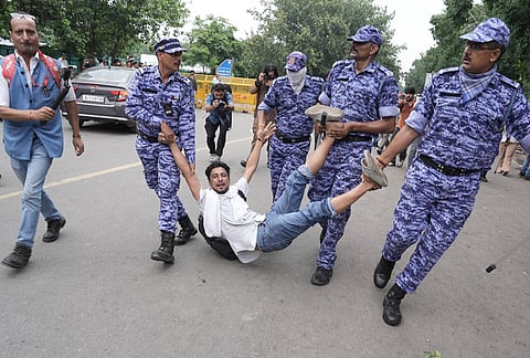 Security personnel detain Cockroach Janata Party (CJP) supporters as they raise slogans near the Parliament during a protest march, in New Delhi, Monday, July 20, 2026. 