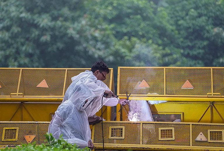 A worker carries out welding work on a barricade ahead of the Cockroach Janata Party's (CJP) protest march, at the Jantar Mantar, in New Delhi, early Monday, July 20, 2026. - | Photo: PTI/Karma Bhutia