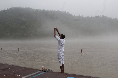 A man offers prayers at Triveni Ghat amid dense mist after rainfall, in Rishikesh, Uttarakhand.