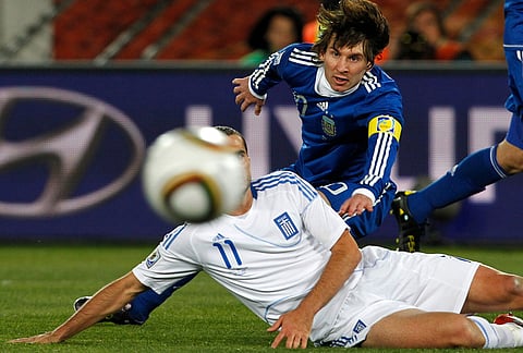 Argentina's Lionel Messi, right, eyes the ball during a challenge with Greece's Loukas Vyntra during the World Cup group B soccer match in Polokwane, South Africa, June 22, 2010. 