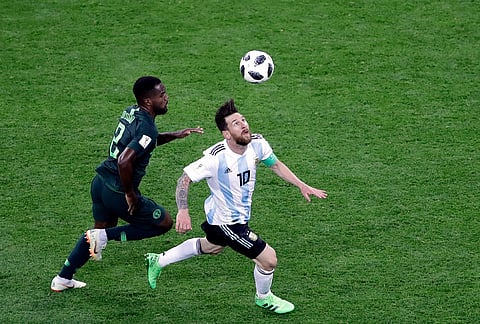 Argentina's Lionel Messi runs for the ball with Nigeria's Bryan Idowu, left, during a group D World Cup match in St. Petersburg, Russia, June 26, 2018. 