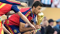 (AP Photo/Frank Franklin II) : Spain's Rodri (16) kisses the winners' trophy as he celebrates with teammates after their win in the World Cup final soccer match against Argentina in East Rutherford, N.J., near New York, Sunday, July 19, 2026. 