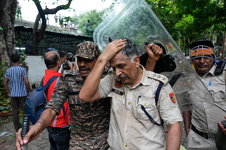 An injured police officer is taken for treatment after being hurt during clashes with supporters of the Cockroach Janta Party attempting to march toward Parliament in New Delhi - | Photo: AP/Manish Swarup