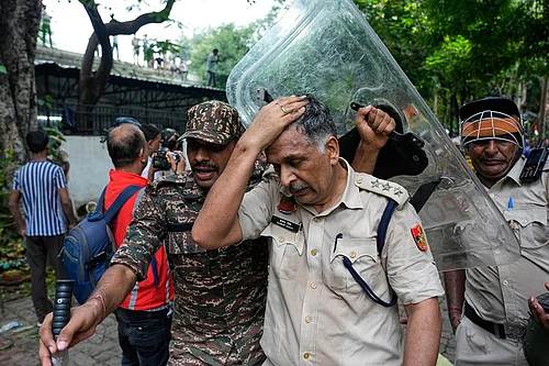 | Photo: AP/Manish Swarup : An injured police officer is taken for treatment after being hurt during clashes with supporters of the Cockroach Janta Party attempting to march toward Parliament in New Delhi