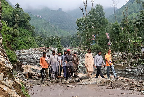 Residents gather in the aftermath of torrential rain-triggered landslides and flash floods, at Dhara Sangla village of Surankote tehsil, in Poonch district, Jammu and Kashmir, Sunday, July 19, 2026. 