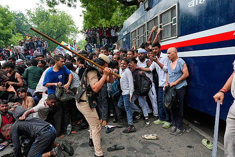 Police use batons to disperse supporters of the Cockroach Janta Party as they attempt to march toward India's Parliament, demanding the resignation of the education minister, in New Delhi.
