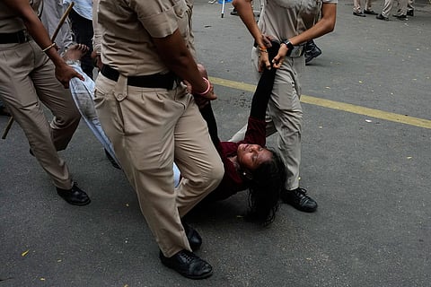 Police detains a supporter of the Cockroach Janta Party as they attempt to march toward India's Parliament, demanding the resignation of the education minister, in New Delhi, India.