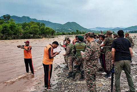 Rescue personnel conduct a rescue operation to rescue two men stranded in a river after flash floods caused by incessant overnight rainfall, in Rajouri, Jammu and Kashmir, Sunday, July 19, 2026. 