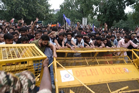 Security personnel stop Cockroach Janata Party (CJP) supporters as they raise slogans during a protest march, at Sansad Marg, in New Delhi, Monday, July 20, 2026.