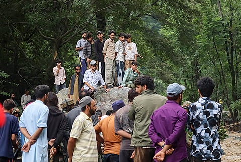 Residents gather in the aftermath of torrential rain-triggered landslides and flash floods, at Dhara Sangla village of Surankote tehsil, in Poonch district, Jammu and Kashmir, Sunday, July 19, 2026. At least 12 people were killed and several others missing as rains unleashed landslides and flash floods across the twin border districts of Poonch and Rajouri in the union territory on Sunday, causing widespread damage to public and private infrastructure including roads and houses, officials said. 