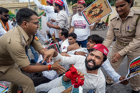 Police personnel detain Samajwadi Party workers during a protest march outside the Uttar Pradesh Legislative Assembly against the proposed demolition of 38 out of 40 buildings at Mohammad Ali Jauhar University, in Lucknow.