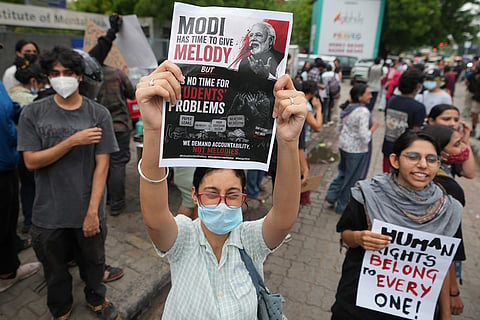 A protester holds a poster during a protest demanding the resignation of India's education minister in Ahmedabad, India.