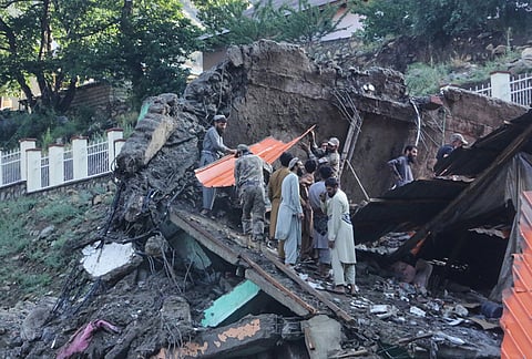 Residents and rescue workers inspect buildings damaged by heavy flooding in the eastern province of Nuristan, Afghanistan, Tuesday, July 21, 2026. 