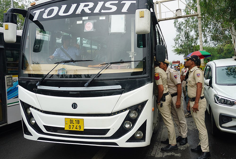 Police personnel inspect a vehicle ahead of a farmers rally 