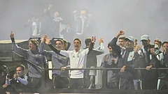 Argentina coach Lionel Scaloni, center, surrounded by team members, waves to fans from a bus heading to the Argentine Football Association headquarters in Ezeiza, on the outskirts of Buenos Aires, Monday, July 20, 2026, after returning from the World Cup final, where they lost to Spain. - | Photo: AP/Gustavo Garello
