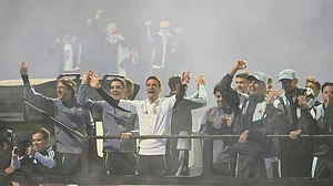 | Photo: AP/Gustavo Garello : Argentina coach Lionel Scaloni, center, surrounded by team members, waves to fans from a bus heading to the Argentine Football Association headquarters in Ezeiza, on the outskirts of Buenos Aires, Monday, July 20, 2026, after returning from the World Cup final, where they lost to Spain.