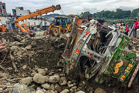Damaged vehicles lie in a debris-strewn area following landslides and heavy rain, in Rajouri, Jammu and Kashmir.