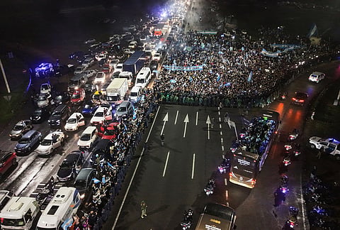 The bus transporting Argentina's players, right, arrives in Ezeiza, Argentina, Monday, July 20, 2026, after Argentina lost to Spain in the World Cup final. 