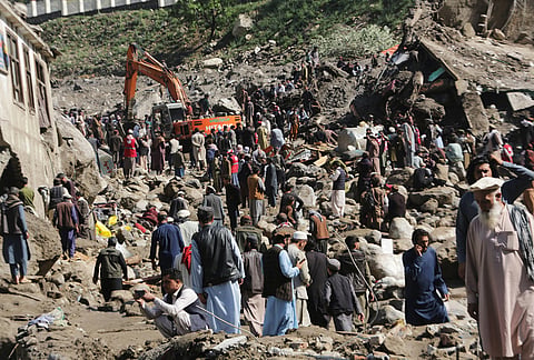 Residents and rescue workers inspect buildings damaged by heavy flooding in the eastern province of Nuristan, Afghanistan, Tuesday, July 21, 2026. 