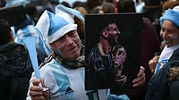 Argentina Return Home Without Their Iconic Captain After World Cup Final Heartbreak AP : A fan holds a portrait of Lionel Messi near the Argentinian Football Association training camp in Ezeiza, Buenos Aires Province, on July 20, 2026, while waiting for the arrival of Argentina's team from the United States