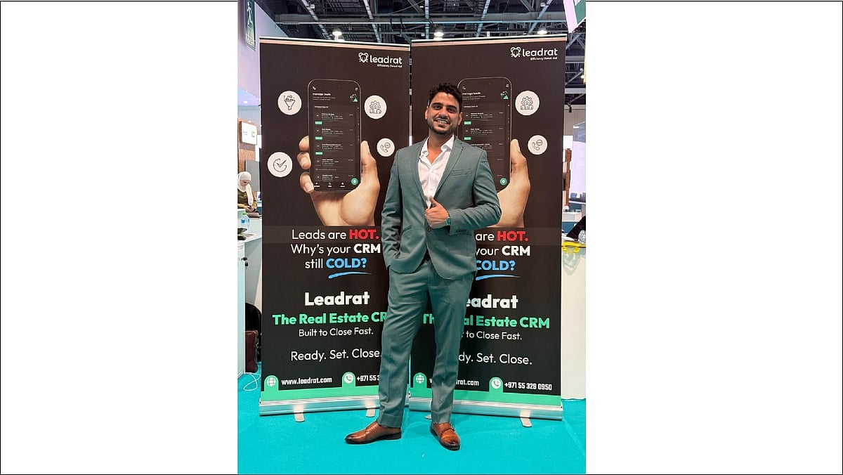 Himanshu Kumar standing in front of the Leadrat real estate CRM exhibition banners - null