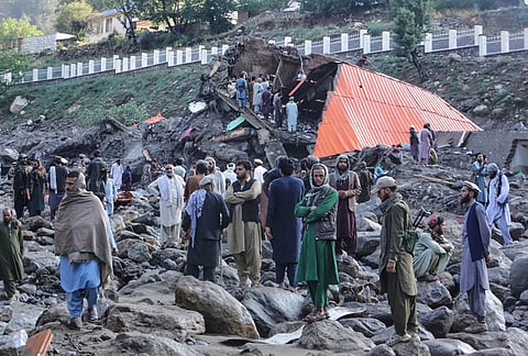 Residents and rescue workers inspect buildings damaged by heavy flooding in the eastern province of Nuristan, Afghanistan, Tuesday, July 21, 2026. 