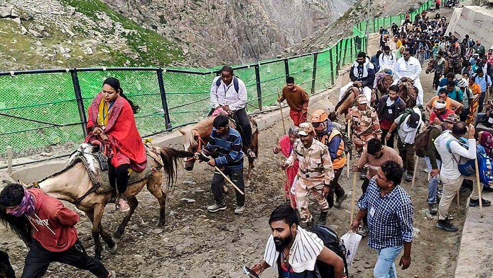 Pilgrims proceed towards the holy cave shrine of Amarnath during the ongoing 'Amarnath Yatra', in Jammu. - | Photo: PTI