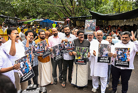 CPI (M) MP John Brittas and others raise slogans as they visit Jantar Mantar during a protest by Cockroach Janata Party founder (CJP) demanding the resignation of Union Education Minister Dharmendra Pradhan over alleged irregularities in the NEET examination, a day after police action on students during the ‘Sansad Chalo’ march, in New Delhi, Tuesday, July 21, 2026. 