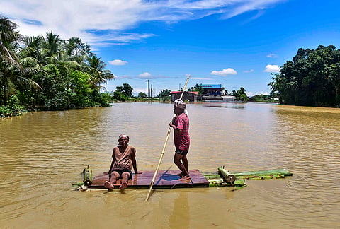 People move to a safer place in a flood-affected area following incessant heavy rainfall, at Phulpanisiga in Sivasagar district, Assam, Tuesday, July 21, 2026. 