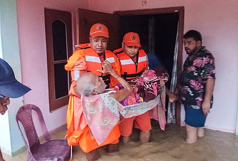 NDRF officials conduct a rescue operation in a flood-affected area, in Assam. 