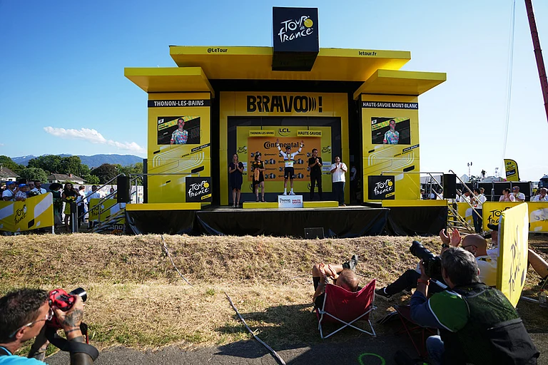 Photographs take pictures of Belgium's Remco Evenepoel on the podium after winning the sixteenth stage of the Tour de France cycling race, an indivdual time-trial with start in Evian-Les-Bains and finish in Thonon-les-Bains, France. - | Photo: AP/Thibault Camus