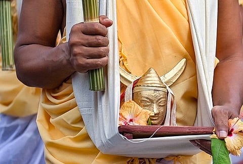 A tribal priest carries a miniature idol of a deity during ‘Kharchi Puja’ to perform rituals at Chaturdas Devata Temple on the outskirts of Agartala. Kharchi Puja is a week-long festival in Tripura, celebrated annually in July or August and is centered around the worship of 14 ancestral deities (Chaturdasa Devata). 
