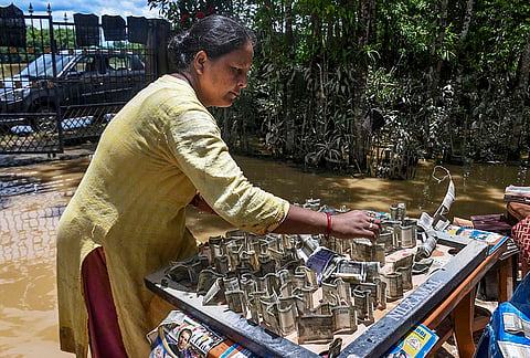 A woman dries currency notes after they get soaked in a flood-affected area, in Jorhat district, Assam, Tuesday, July 21, 2026. 