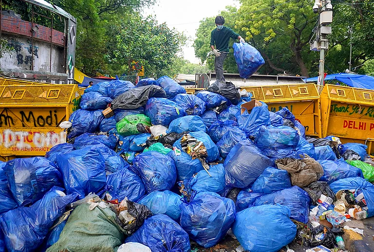 A volunteer stacks garbage bags at one place, during an ongoing protest organised by Cockroach Janata Party (CJP) at the Jantar Mantar, in New Delhi. The agitation, which began on June 20, is demanding accountability over alleged irregularities in competitive examinations, reforms in the education system and the resignation of Union Education Minister Dharmendra Pradhan, and compensation for families of students who allegedly committed suicide due to the paper leak. - | Photo: PTI
