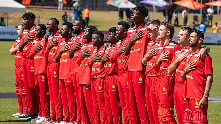 Zimbabwe's players line up in their retro 1992 World Cup-inspired red jerseys for the national anthem before the first T20I against India at Harare Sports Club, paying tribute to a landmark era in the nation's cricket history. - X/ZimCricketv