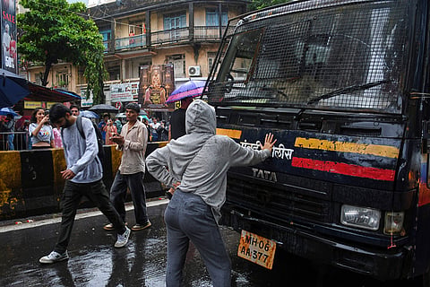 Rhiya Ahir, a model, blocks a police van carrying detained protesters during a demonstration demanding educational reforms as part of the Cockroach Janta Party's ongoing protest movement in Mumbai, India.