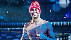 Chad le Clos gives a thumbs-up beside the pool wearing a festive red beanie - X/chadleclos