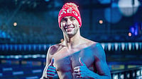 X/chadleclos : Chad le Clos gives a thumbs-up beside the pool wearing a festive red beanie
