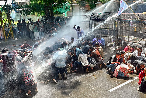 Police use water cannon to disperse the Students' Federation of India (SFI) activists during a protest march demanding the resignation of Union Education Minister Dharmendra Pradhan over alleged irregularities in the NEET examination, in Thiruvananthapuram, Thursday, July 23, 2026. 
