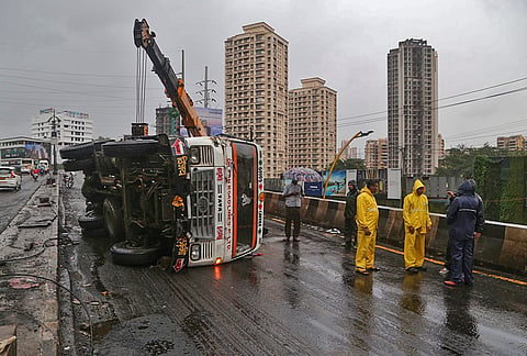A truck being towed away after it lost control and overturned on Patlipada Bridge along Ghodbunder Road, in Navi Mumbai, Maharashtra.