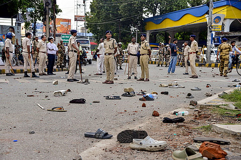 Scattered footwear and brickbats lie on the road as police personnel remain deployed at the site following stone-pelting during the 'Lok Bhavan March' by All India Students Association (AISA) activists demanding the resignation of Union Education Minister Dharmendra Pradhan over alleged irregularities in the NEET examination, in Patna, Bihar.