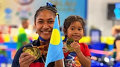 Samoa wrestler Seine Stowers posing with her daughter, flexing her medals - Insta/ Vodafone Samoa