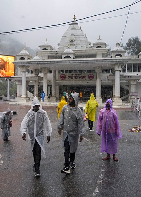 Stranded devotees gather outside the Darshani Deodi as the Vaishno Devi Yatra remains temporarily suspended due to inclement weather, at Karta in Reasi, Tuesday, July 21, 2026. 