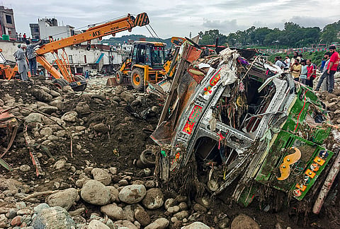 Damaged vehicles lie in a debris-strewn area following landslides and heavy rain, in Rajouri, Jammu and Kashmir, Monday, July 20, 2026. 