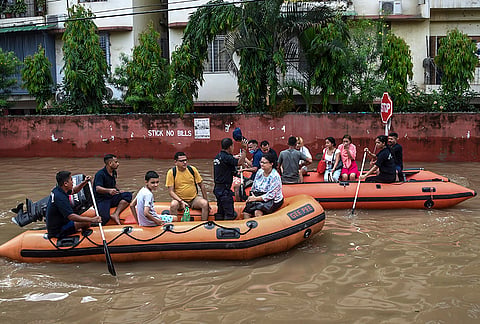SDRF personnel rescue people from a water logged area following rainfall, at Rukmini Gaon, in Guwahati.